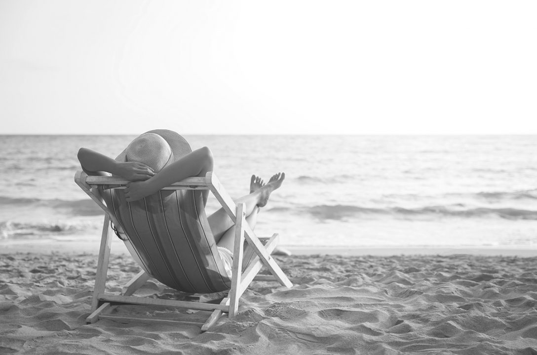 person in chair looking at ocean